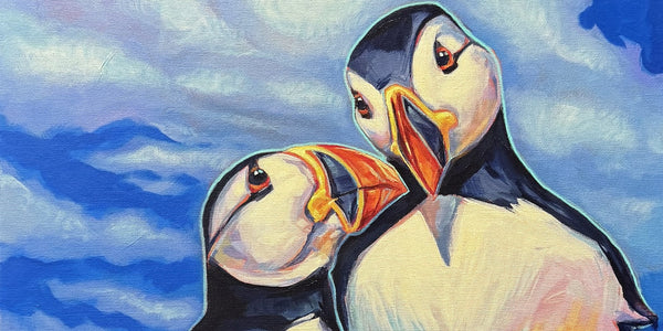 Lovebirds by Adam Young, close view of two Atlantic puffins leaning their heads together against a blue sky